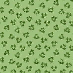 Dark Irish Green Shamrocks scattered in an all over pattern on a green background