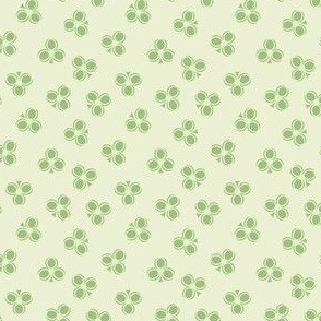 Green Shamrocks scattered in an all over pattern on a pastel light green background 