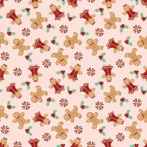 Small Christmas Gingerbread Men and Women surrounded by Holly and Round Peppermint Candy with Pale Pink Background