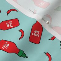 (S Scale) Hot Stuff | Hot Sauce Bottle with Peppers Scattered on Light Blue