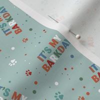 Colorful rainbow barkday design with confetti paws and happy birthday text for dogs on soft teal 