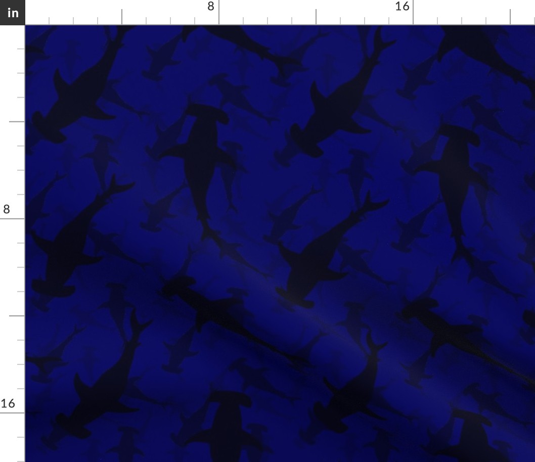 Hammerhead Sharks in Dark Silhouette Circling in Dark Blue Water