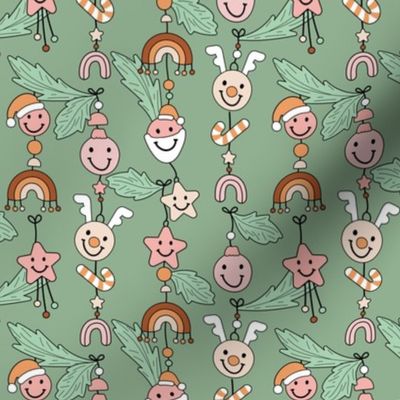 Cozy Christmas kawaii decoration - Happy holidays seasonal smiley design with raindeer bells stars rainbows and christmas ornaments hanging on branches pink orange on sage green
