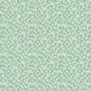 Small ditsy sweet floral spring blooms in cream on green