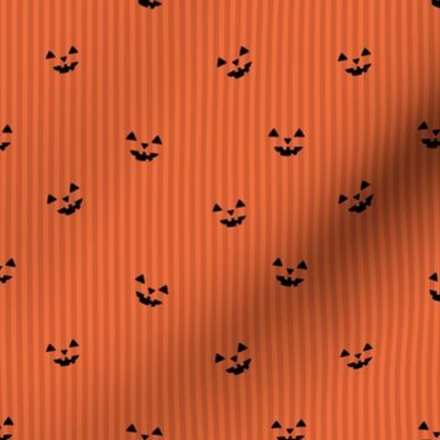Pumpkin carving spooky eyes on orange stripes minimalist halloween design orange rust