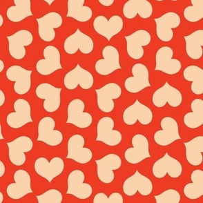 Elegant beige hearts arranged in a polka dot manner on a red background. 