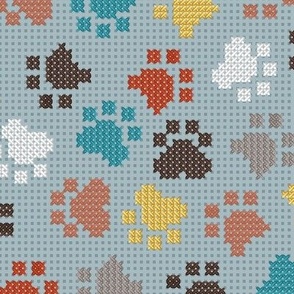Normal scale // Pawsome cross stitch // heather blue background yellow brown and peacock blue paw prints
