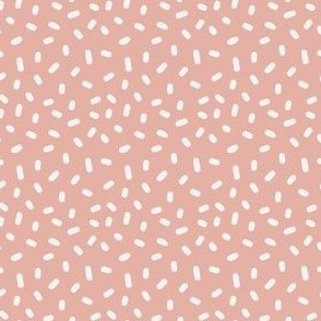 Tossed cream white candy sprinkles on dusty pink