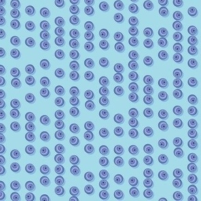 Blueberries arranged in stripes on a light blue background