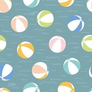 Colourful green, blue, pink, teal, yellow beach balls on teal background 