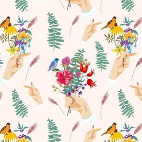 Summer wildflowers bouquet with birds and woman hand