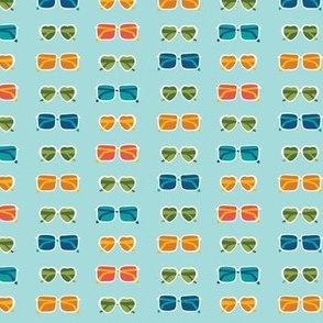 Colorful sunglasses in various shapes on light baby blue - summer fabric, home decor