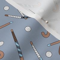 Field Hockey - Hockey sticks and balls tossed freehand boho style sports design cool gray on moody blue