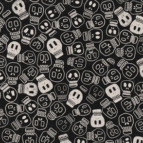 white skulls condensed on textured black background for Halloween