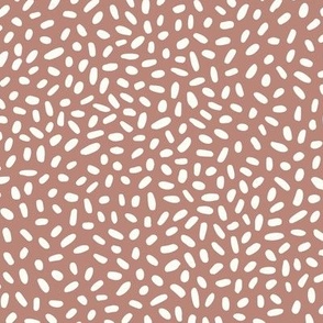 MEDIUM - Neutral scattered dots in white over brown background