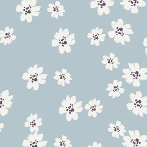 Ivory ditsy flowers tossed on blue wallpaper