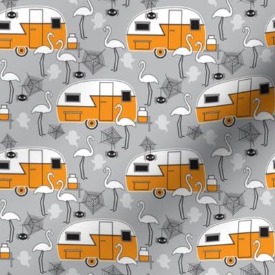 small halloween trailers and flamingos on grey