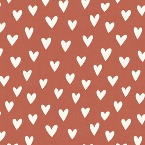 cream hearts on rust red-brown background
