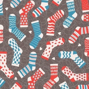 Mismatching red, blue, white socks, on squiggly gray-brown, odd socks