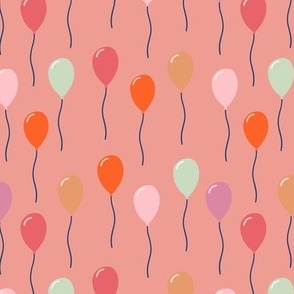 Colourful birthday balloons on pink