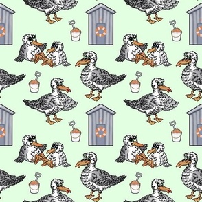 Seagull, beach hut, bucket & spade seaside pattern on mint green.