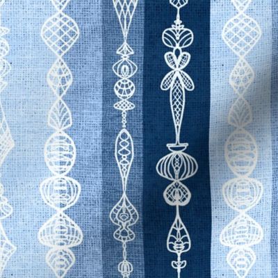 Vertical burlap textured stripes with white handdrawn lace effect overlay small 12” repeat monochrome blues. Light blue, denim blue, indigo blue 