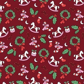 Cutesy Christmas retro wreath mistletoe candy cane pudding moon rocking horse and stockings seasonal ornaments and icons pink red green on burgundy