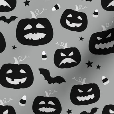 Happy scary Halloween pumpkins with bat silhouettes and candy corn - black, white and gray