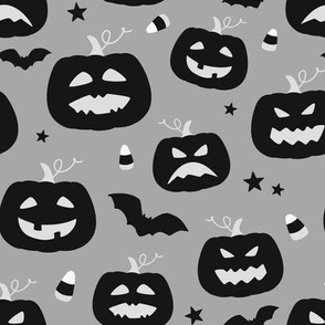 Happy scary Halloween pumpkins with bat silhouettes and candy corn - black, white and gray