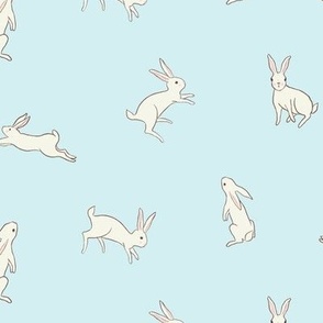 Leaping white bunny rabbits on a baby blue background