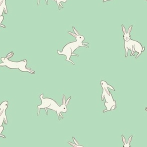 Leaping white bunny rabbits on mint