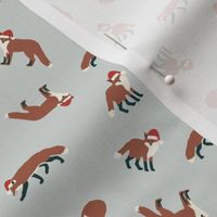 Red Foxes in Santa Hats Tossed in Earth Tones on a Light Blue Background