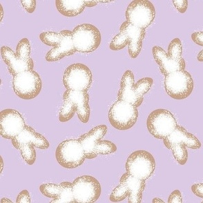 Little minimalist Easter bunnies - baked spring cookies powdered sugar on cookie dough on lilac purple