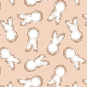 Little minimalist Easter bunnies - baked spring cookies powdered sugar on cookie dough on blush peach 