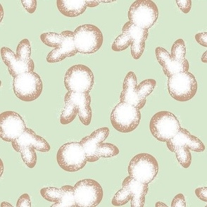 Little minimalist Easter bunnies - baked spring cookies powdered sugar on cookie dough on mint green