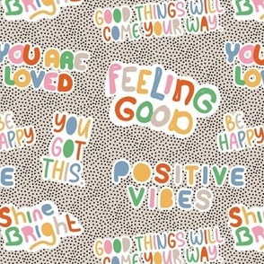 Positive vibes and happy affirmation stickers - freehand quote rainbow text design to cheer you up on tiny spots black on sand