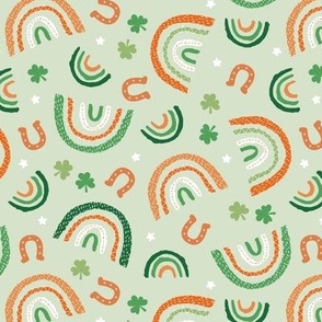 St Patrick's Day rainbows and lucky horse shoe stars and shamrock leaves pink blue lilac orange green on mint green