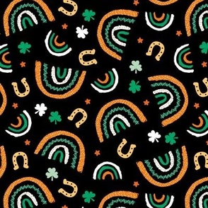 St Patrick's Day rainbows and lucky horse shoe stars and shamrock leaves orange green on black 