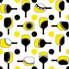 yellow and white paddles with black and orange balls white outline