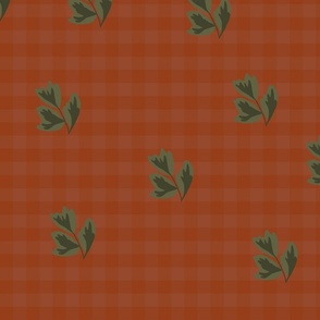 Green leaves on red plaid background 