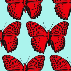 large spotted butterflies red and black on light turquoise