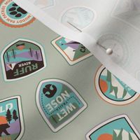 Dog adventures - tossed vintage springtime camping stickers and mountain badges with wet noses muddy paws and summer camp nature patches retro teal blue green orange on sage green