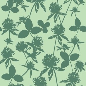 Silhouettes of flowers and clover leaves in green background