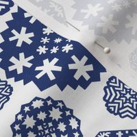 Paper cut out delicate dark blue snowflakes on an white background