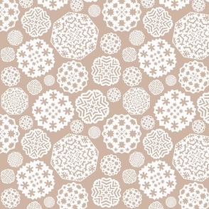 Paper cut out white snowflakes on a beige background