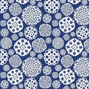 Paper cut out white snowflakes on a dark blue background