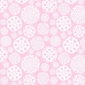 Paper cut out white snowflakes on a pink background