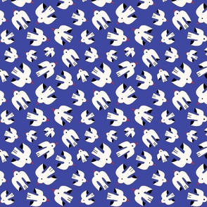 Flock of white birds flying through the summer sky on a dark blue background - small scale