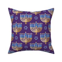 Golden hanukkah menorah with candles on textured purple | medium