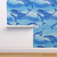 Whales swimming in tranquil waters in the deep blue ocean on ocean blue and aqua blue background